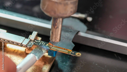 Obraz na płótnie Professional electronics repair specialist removing damaged port with solder wic