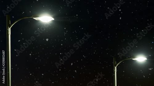 Streetlights shining in snowfall during night sky  