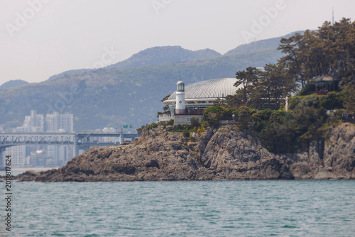 Nurimaru APEC House, Busan, South Korea, Dongbaek Park on Haeundae Dongbaekseom Island, with Dongbaekseom Lighthouse and mountain, Busan Bay marina skyline, conference center venue and memorial hall