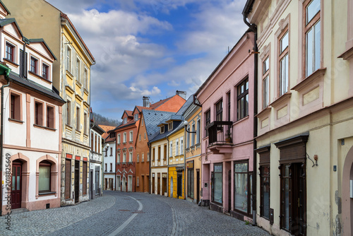 Historic street in Loket town, Czech Republic. Cobblestone road and colorful medieval houses under cloudy sky