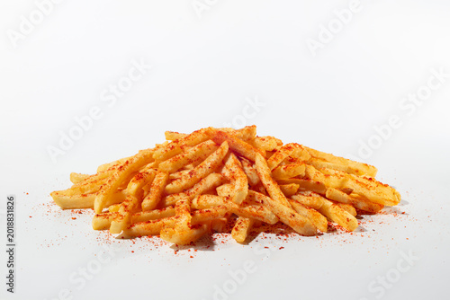 Spicy French fries with red spice sprinkles on top. Isolated on a white background 