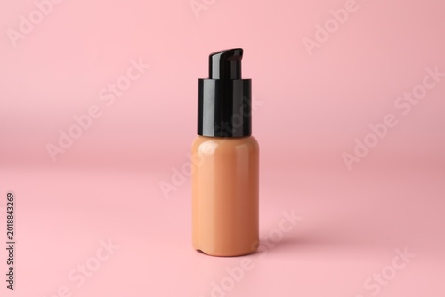 Skin foundation in bottle on pink background, closeup