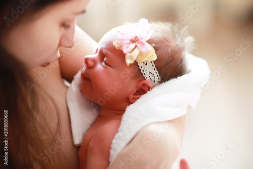 Bild auf Leinwand A newborn baby lies in her mother's arms