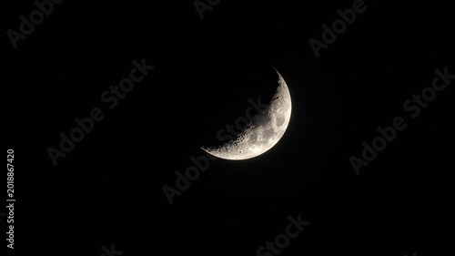 Distant Moon Crescent Against Black Space