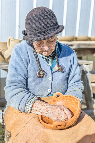  Cauquenes, Chile - March 26, 2026: An artisan proceeds to burnish clay pieces such as bowls, cups and jugs with an agate stone.