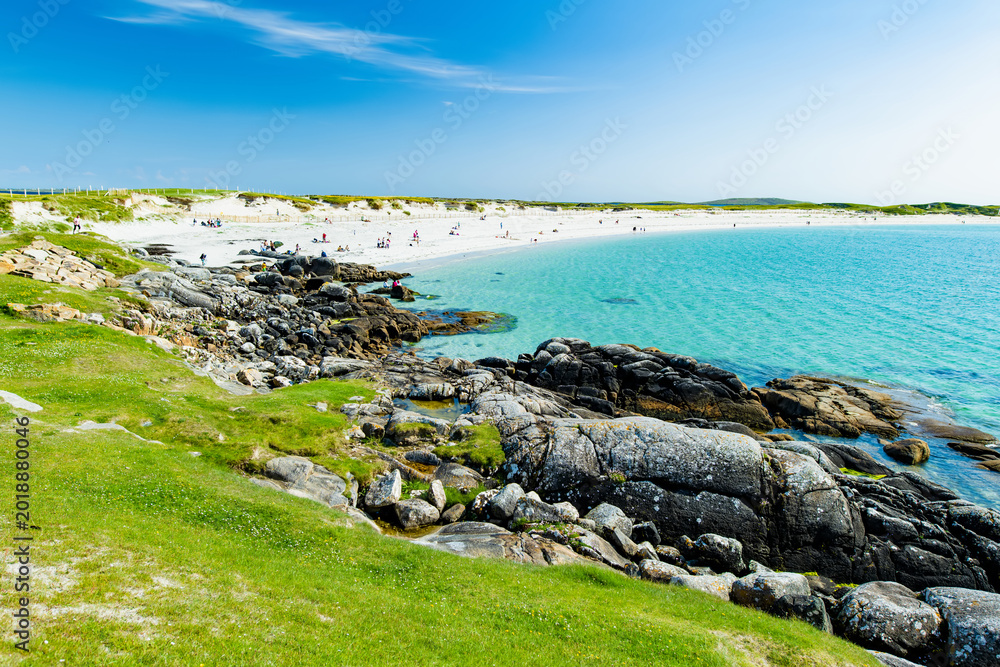 Naklejka premium Rocky shoreline and turquoise water at Dogs Bay near Roundstone, Connemara, County Galway. Scenic white sand beach on the Wild Atlantic Way beside Gurteen Bay, Ireland