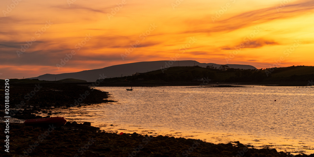Obraz premium Sunset view of Clew Bay near Westport, County Mayo, Ireland. Scenic orange evening light over the Atlantic inlet and mountains on the Wild Atlantic Way.