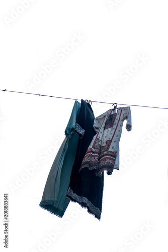 Canvas Print Women churidar suit are hanging on sunlight after ring-dyeing to dry on isolated white background