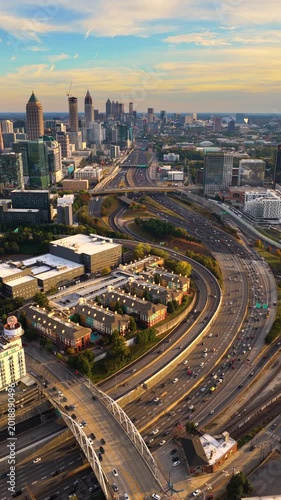 Atlanta, Georgia skyline with prominent skyscraper buildings and expressway stretching across the city. Dense highway traffic and modern transportation infrastructure.