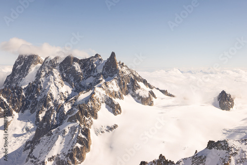 Bild auf Leinwand Cloud Brushing Across Snowy Peaks at Aiguille du Midi
