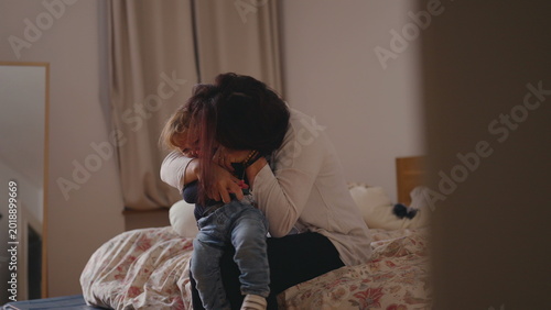 Tableau sur toile Mother hugging toddler tightly on bed with warm affectionate embrace creating te