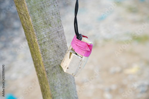 Canvastavla a close up of a weathered wooden post with a makeshift object hanging from it bo