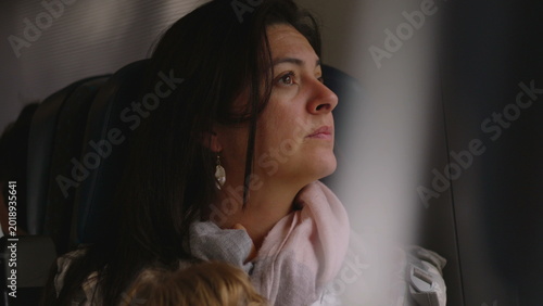 Fotografie Woman gazing out train window with soft reflective expression creating calm mome