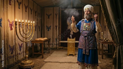 Jewish high priest praying in ancient tabernacle with incense and menorah. Biblical scene of faithful man performing religious sacrifice inside sacred tent area.