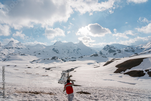 Foto Mujer en la nieve rodeada de montañas durante una aventura invernal al aire libre