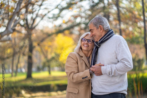 фотографія Happy senior couple enjoying a romantic autumn day in the park together