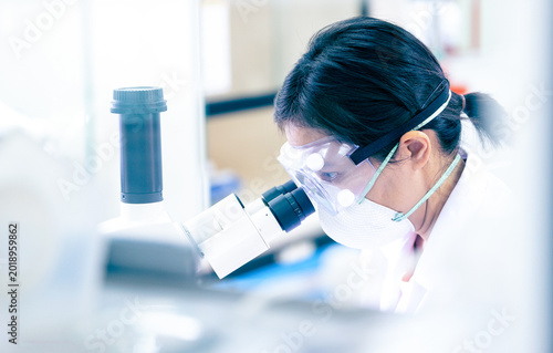 Close up of Scientist hands with microscope in medical research lab or science laboratory.