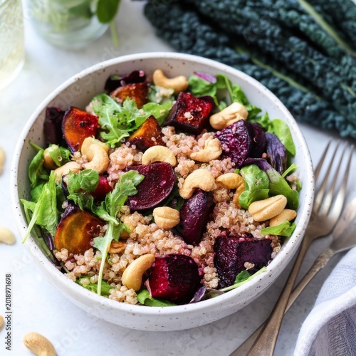 Salad Bowl With Greens, Beets, Quinoa, and Cashews on a Gray Table With Nuts ...