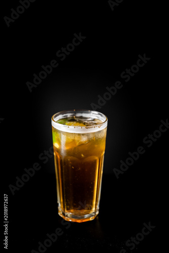 Canvas Print Cold cuba libre cocktail with lime and ice in a highball glass on a dark background
