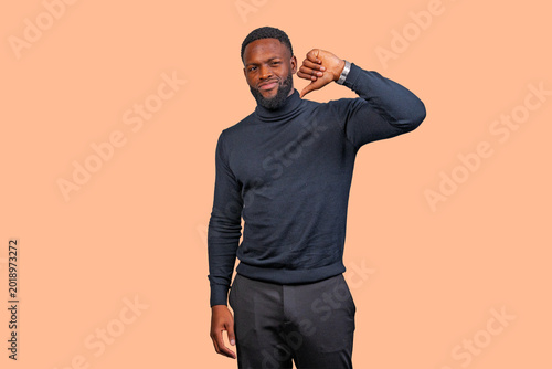Vászonkép African man showing thumbs down for disapproval and dislike