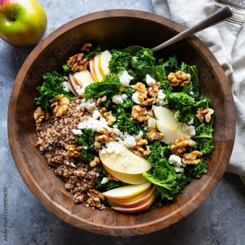 Healthy Salad With Quinoa, Kale, Apples, Walnuts, and Cheese in a Wooden Bowl...