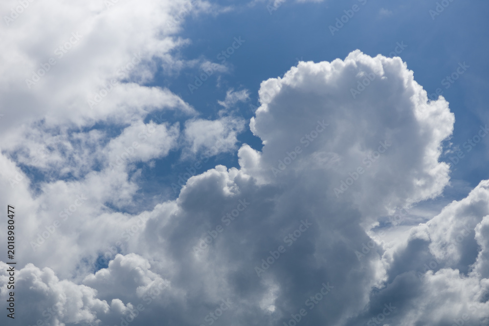 Obraz premium Fluffy white cumulus clouds against a clear blue sky, natural weather background