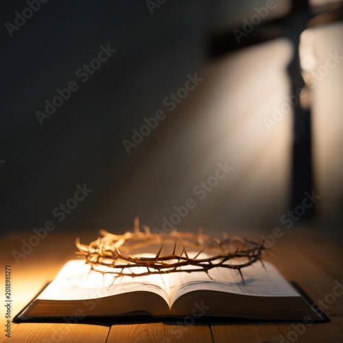 Crown of Thorns Placed on Open Book in Dim Light Near Wooden Cross