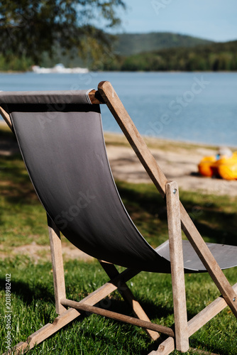 Wooden deck chair beside peaceful lakeshore