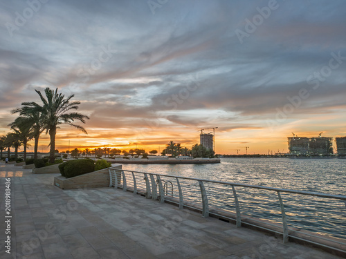 Sunset Over Al Raha Beach, Abu Dhabi with Palm Trees and Waterfront Promenade