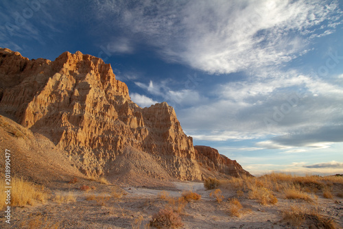 Bild auf Leinwand Golden evening light illuminates dramatic eroded cliffs and desert terrain at Cathedral Gorge State Park in eastern Nevada
