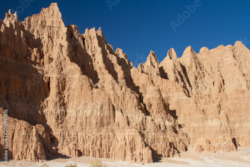 Sunlit clay cliffs and jagged spires showcase the striking erosion-carved landscape of Cathedral Gorge State Park in Nevada's high desert.