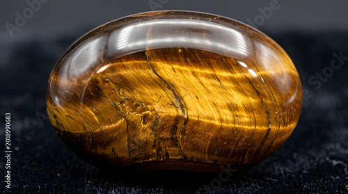 polished tiger s eye gemstone close up on golden brown mineral with chatoyancy