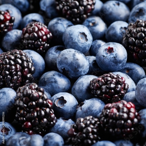 Fresh Blueberries and Blackberries Piled Together on a Surface in Daylight