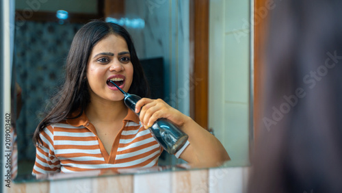Indian Woman Using Water Flosser for Oral Care and Dental Hygiene at Home