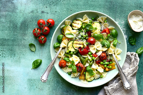 Traditional italian pasta primavera with spring vegetables. Top view with copy space.