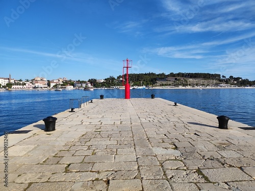 Rovinj harbor pier with red navigation beacon and Adriatic Sea, Croatia