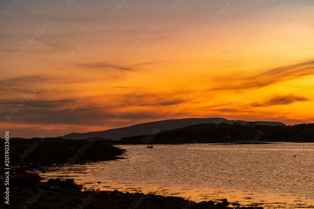 Naklejka premium Sunset view of Clew Bay near Westport, County Mayo, Ireland. Scenic orange evening light over the Atlantic inlet and mountains on the Wild Atlantic Way.