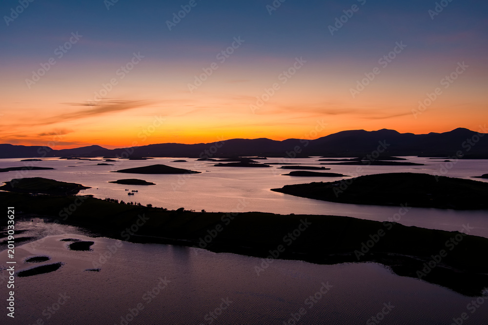 Naklejka premium Aerial sunset view over Clew Bay near Westport, County Mayo, Ireland. Scenic Atlantic bay with drumlin islands and mountain silhouettes on the Wild Atlantic Way.
