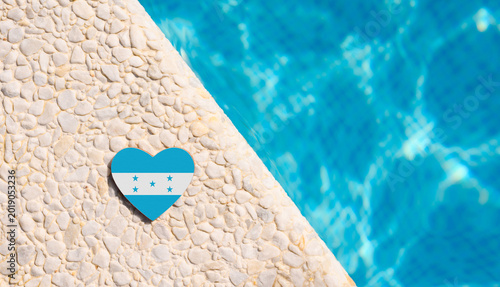Flag of Honduras in the shape of a heart near the pool in the hotel. Holiday concept in Honduras