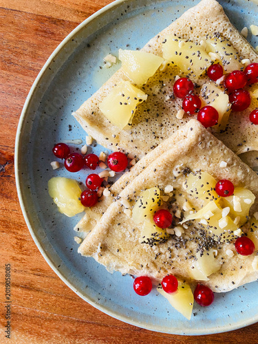 Close-up flat lay of healthy Oat crepes with kiwi, pomegranate and chia seeds