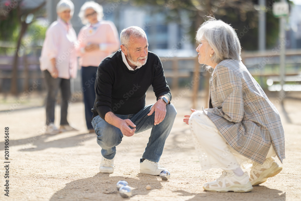 Obraz premium Focused elderly people analyzing results of petanca game while spending leisure time outdoors