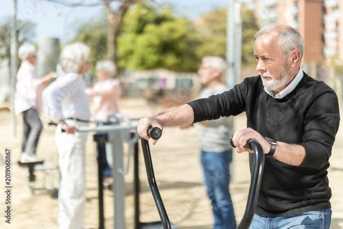 Photos Elderly men and women people keep fit and wellness, exercise outdoors, and use outdoor exercise equipment public sports ground