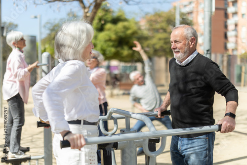 Photos Elderly men and women people keep fit and wellness, exercise outdoors, and use outdoor exercise equipment public sports ground