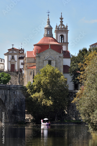 Rear of the Church of São Gonçalo in Amarante, Portugal, Tâmega River, couple in a small boat with a sun umbrella taking a romantic ride