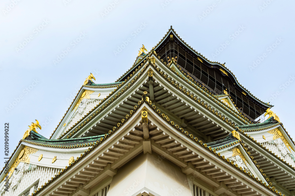 Obraz premium Intricate roofline of the historic Osaka Castle in Spring, low angle view