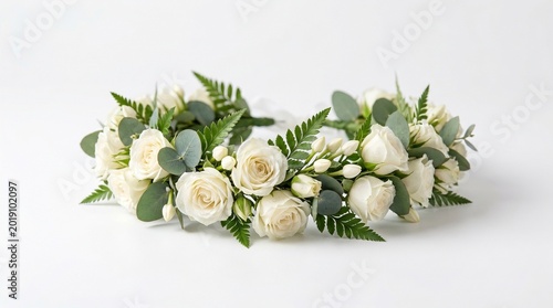 A floral bridal crown made of white flowers and greenery rests in a clean composition, isolated on white background with soft natural shadows.
