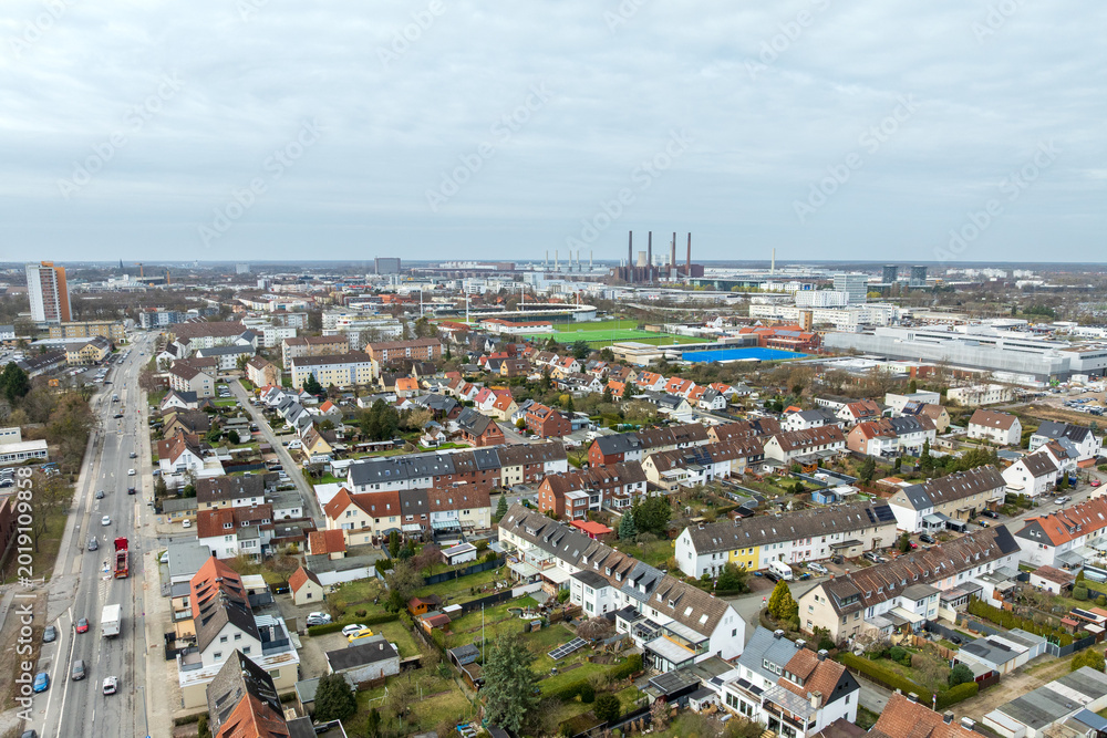 Obraz premium Aerial view of Stadtmitte district in Wolfsburg with residential area and industrial skyline