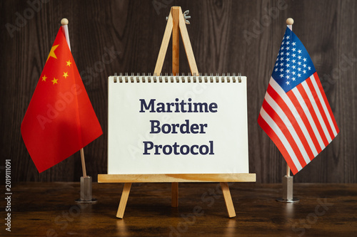 Conceptual image of Maritime Border Protocol shown on notebook with flags. Social awareness and corporate responsibility theme.