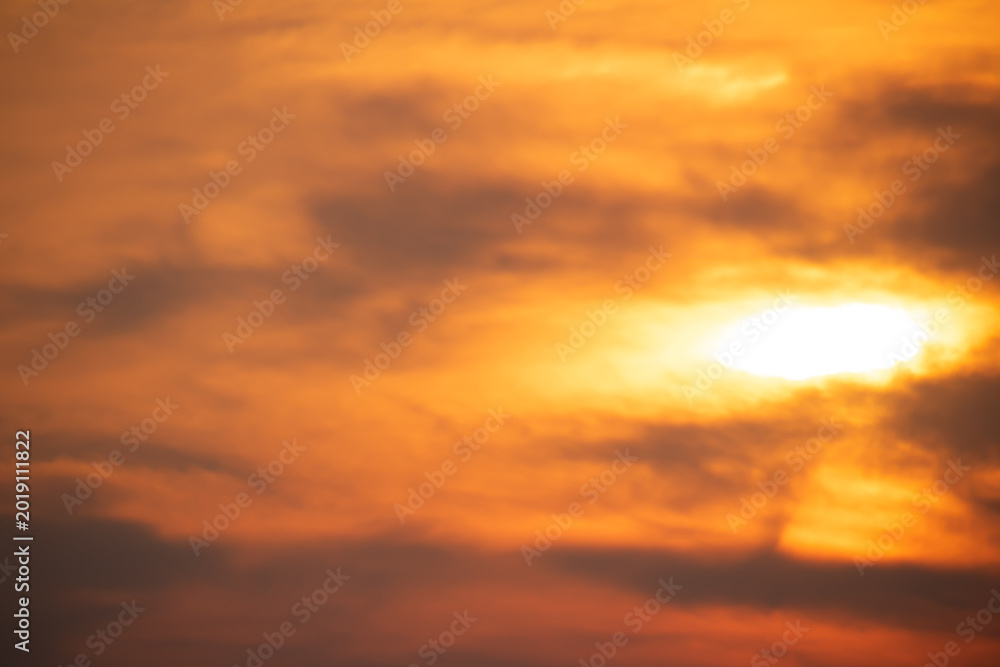 Fototapeta premium Warm orange sunset clouds spreading across the evening sky with glowing sunlight and soft dramatic textures, ideal for backgrounds and atmospheric nature concepts.