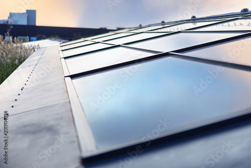 Modern Black Steel Roof with Glass Skylights and Rivets for Contemporary Home or Office Building